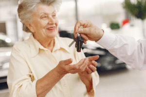 Old couple in a car salon. Family buying the car. Elegant woman with her husband. Senior by a car.